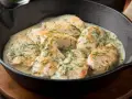 Aromatyczny kurczak w sosie śmietanowym z koperkiem, podany w żeliwnej patelni.