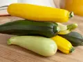 Stos zielonych i żółtych cukinii. Czy cukinia i kabaczek to to samo? Różne odmiany, ale podobne w smaku i zastosowaniu.