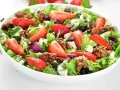 Kolorowa sałatka z truskawkami, serem feta, orzechami i ziołowym dressingiem. Idealna na letnie dni.