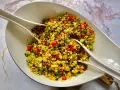 Kolorowa sałatka z kaszą bulgur, pomidorami, ogórkiem i ziołami, gotowa do podania.