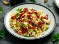 Pyszna sałatka z makaronem orzo, z suszonymi pomidorami, oliwkami, fetą i natką pietruszki.