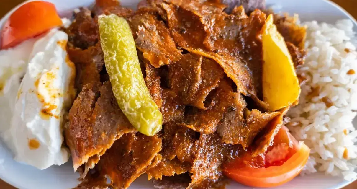 Pyszny kebab z mięsa mielonego z ryżem, jogurtem, pomidorem i pikantną papryczką.