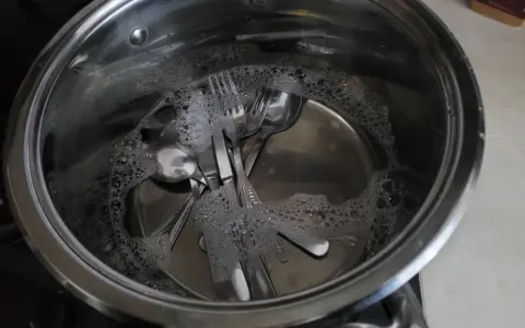 Sztućce ze stali nierdzewnej w wodzie z bąbelkami. Dowiedz się, jak usunąć przebarwienia na stali nierdzewnej.