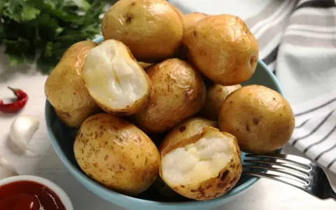 A miseczce pyszne ziemniaki w mundurkach, idealne do sosu. Obok czosnek, papryczka i natka.