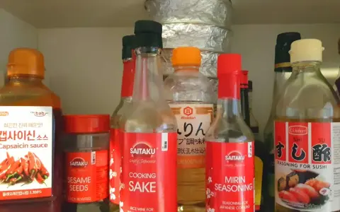 Butelka z napisem "MIRIN SEASONING" obok sosu do sushi i sake. Mirin co to? To japońska przyprawa do gotowania.