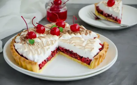 Pyszna tarta z czereśniami, udekorowana pianką i świeżymi wiśniami. Idealna na deser.