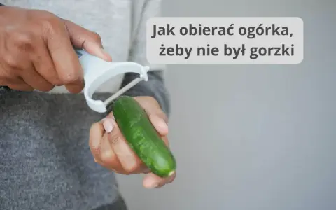 Dłonie obierają ogórka obieraczką. Dowiedz się, od której strony obierać ogórka, by nie był gorzki.