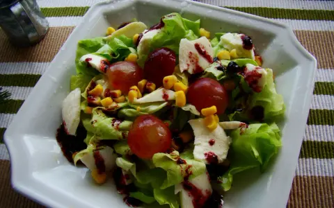 Sałatka z sosem winegret: chrupiąca sałata, winogrona, kukurydza i ser mozzarella polane ciemnym sosem.