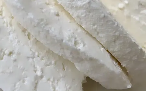 Świeży, biały twaróg z mleka krowiego, pokrojony w kawałki. Idealny do sernika lub na kanapki.