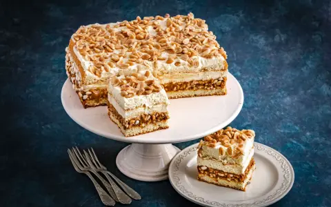 Pyszne ciasto Biały Lion z kremem i orzeszkami, pokrojone na kawałki, gotowe do degustacji.