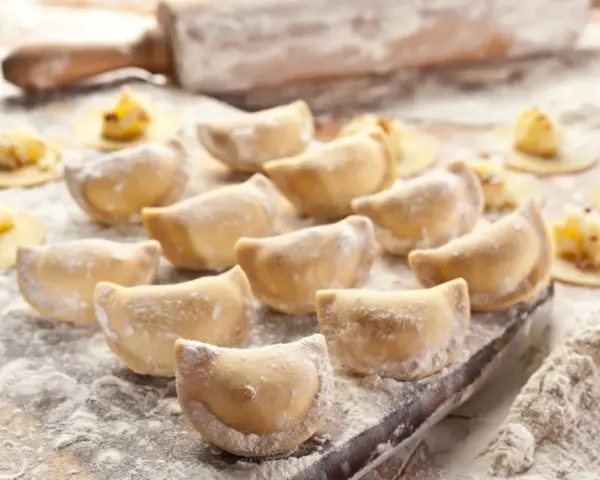 Gotowe do lepienia pierogi, posypane mąką. Zastanawiasz się, jaka mąka na pierogi będzie najlepsza? Ta wygląda idealnie!
