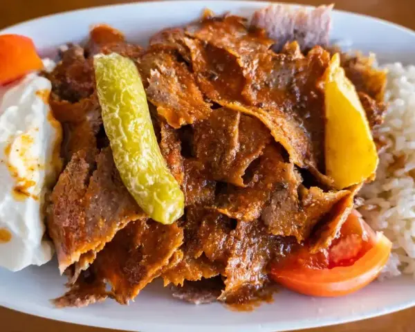 Pyszny kebab z mięsa mielonego z ryżem, jogurtem, pomidorem i pikantną papryczką.
