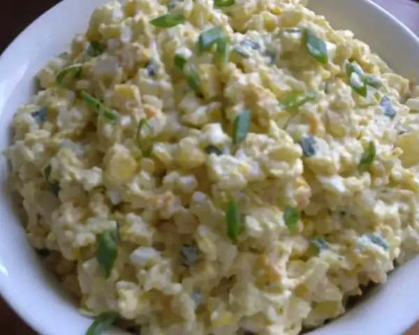 Szybka sałatka z ryżem i jajkiem, z dodatkiem szczypiorku, w białej misce. Idealna na szybki lunch.