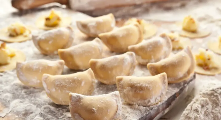 Gotowe do lepienia pierogi, posypane mąką. Zastanawiasz się, jaka mąka na pierogi będzie najlepsza? Ta wygląda idealnie!