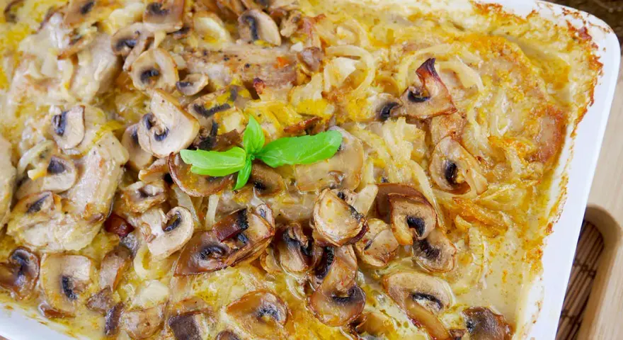 Pyszny schab z pieczarkami w kremowym sosie, zapieczony w naczyniu. Aromatyczne danie, które zachwyci każdego smakosza.