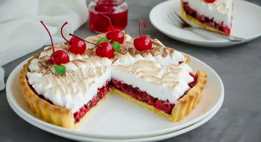 Pyszna tarta z czereśniami, udekorowana pianką i świeżymi wiśniami. Idealna na deser.