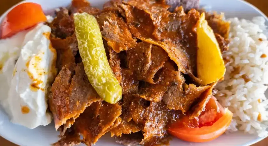 Pyszny kebab z mięsa mielonego z ryżem, jogurtem, pomidorem i pikantną papryczką.