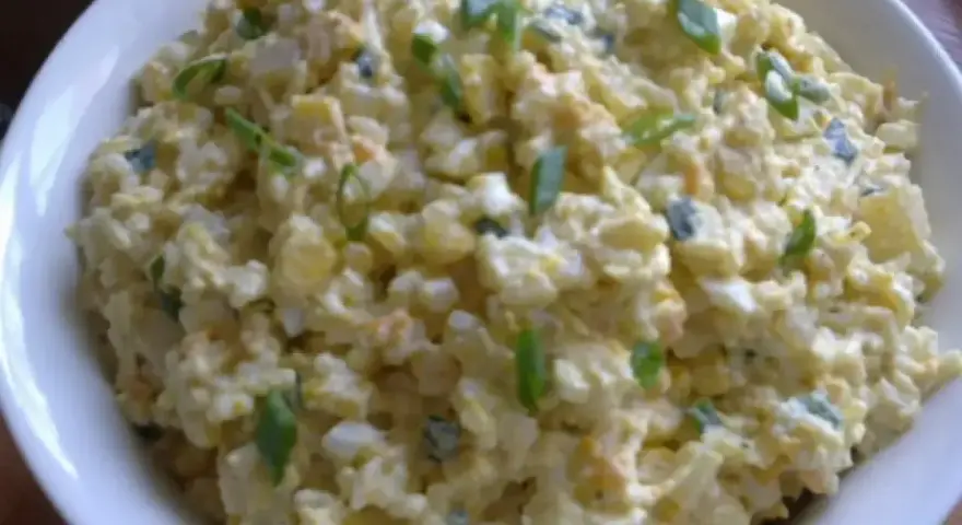 Szybka sałatka z ryżem i jajkiem, z dodatkiem szczypiorku, w białej misce. Idealna na szybki lunch.