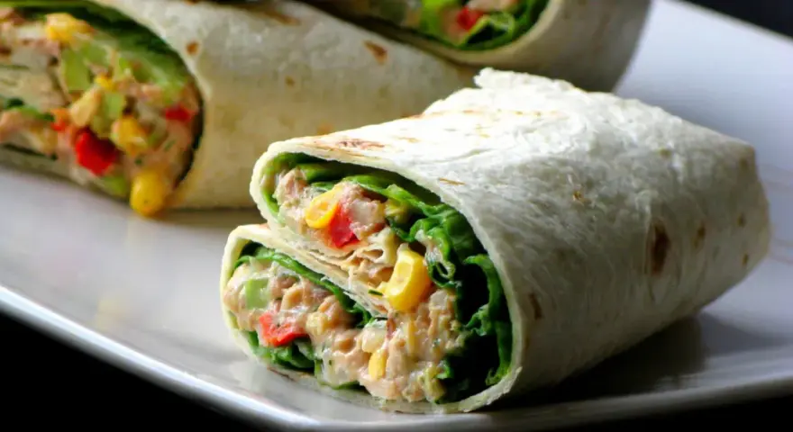 Pyszna tortilla z tuńczykiem, chrupiącą sałatą, kukurydzą i papryką. Idealna na szybki lunch.
