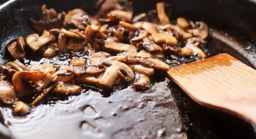 Pokrojone pieczarki smażą się na patelni, tworząc pyszny dodatek do wielu dań. Idealne, by dowiedzieć się, co zrobić z pieczarek.