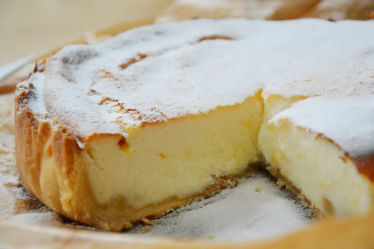 Puszysta pizza z serka wiejskiego, posypana cukrem pudrem, wygląda apetycznie.